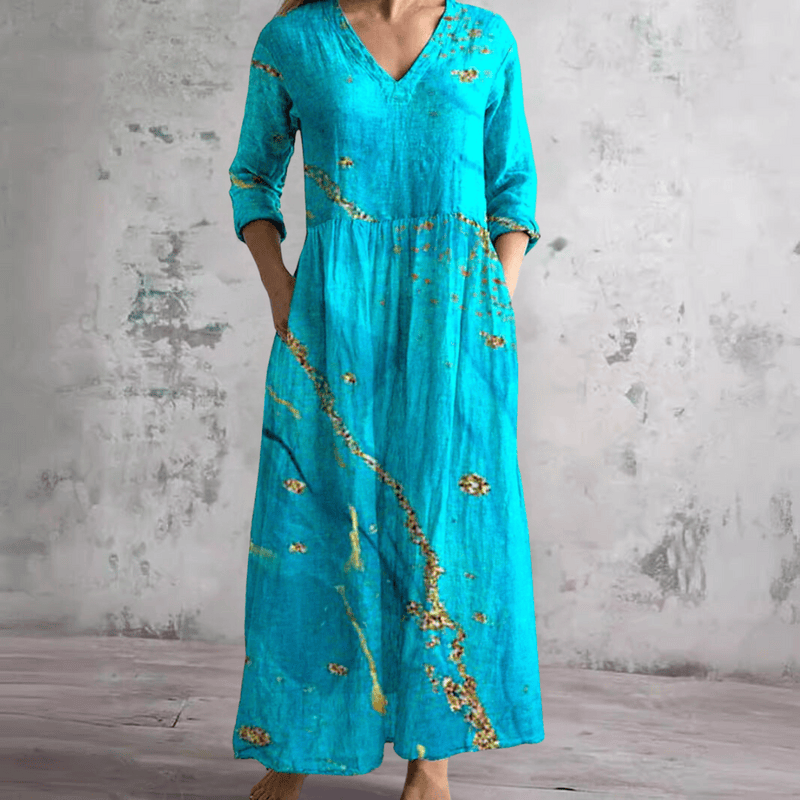 Robe d'été bleue à col V, manches 3/4 et taille froncée, motifs fleuris dorés.