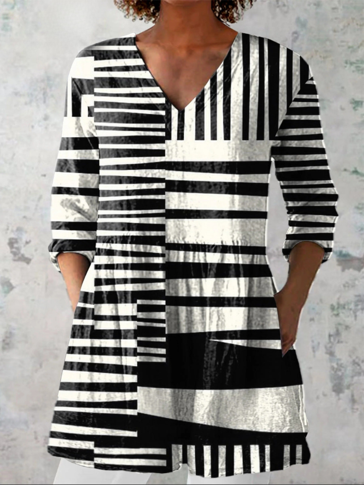 Blouse longue à col en V noire et blanche à rayures, manches longues, coupe ample.