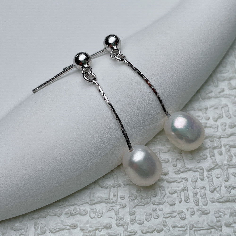 Boucles d’oreilles argentées à perle blanche pendante, chaînes et tiges.