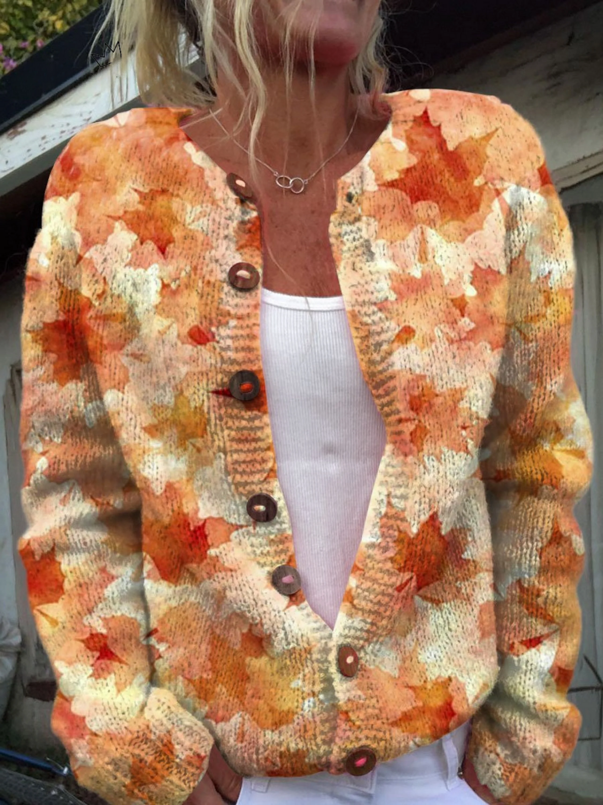 Cardigan vintage en maille à boutons, col en V, motifs orange et beige.