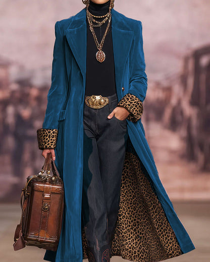 Manteau long bleu à coupe tailleur, col revers, devant ouvert.