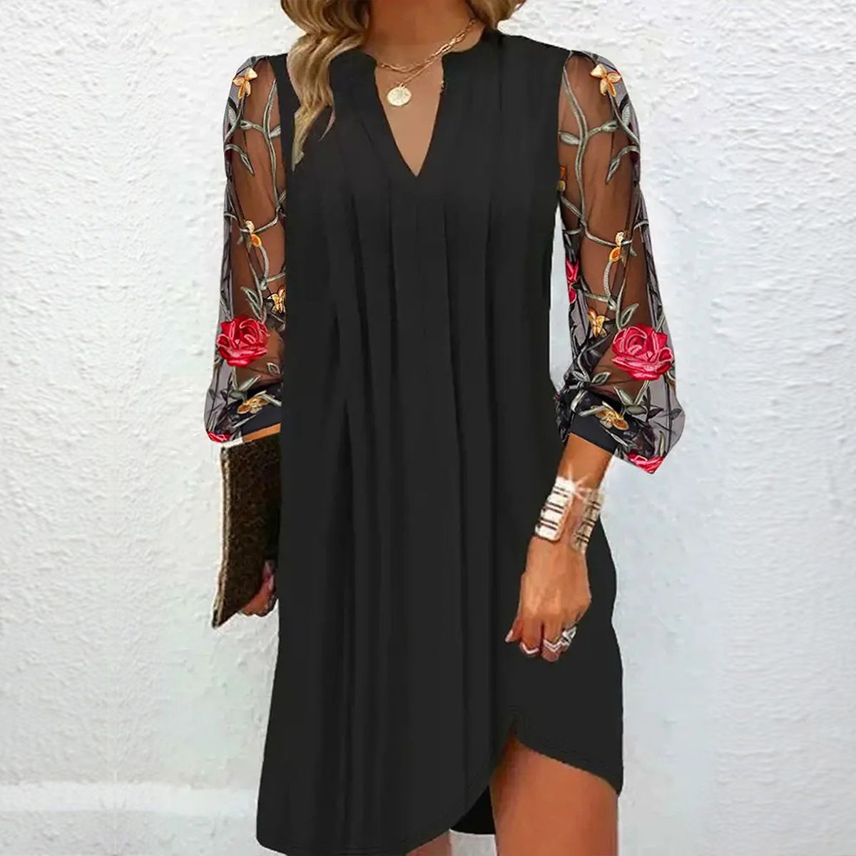 Robe noire à décolleté V, manches longues fleuries multicolores, fente au bas.