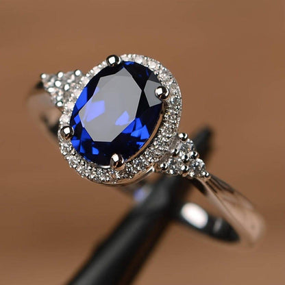 Bague saphir ovale bleu nuit, monture à halo pavé, détails des griffes