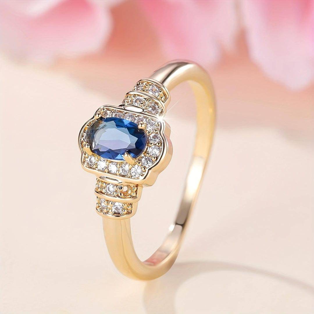 Bague en or sertie d’un saphir bleu entouré de cristaux, monture en halo