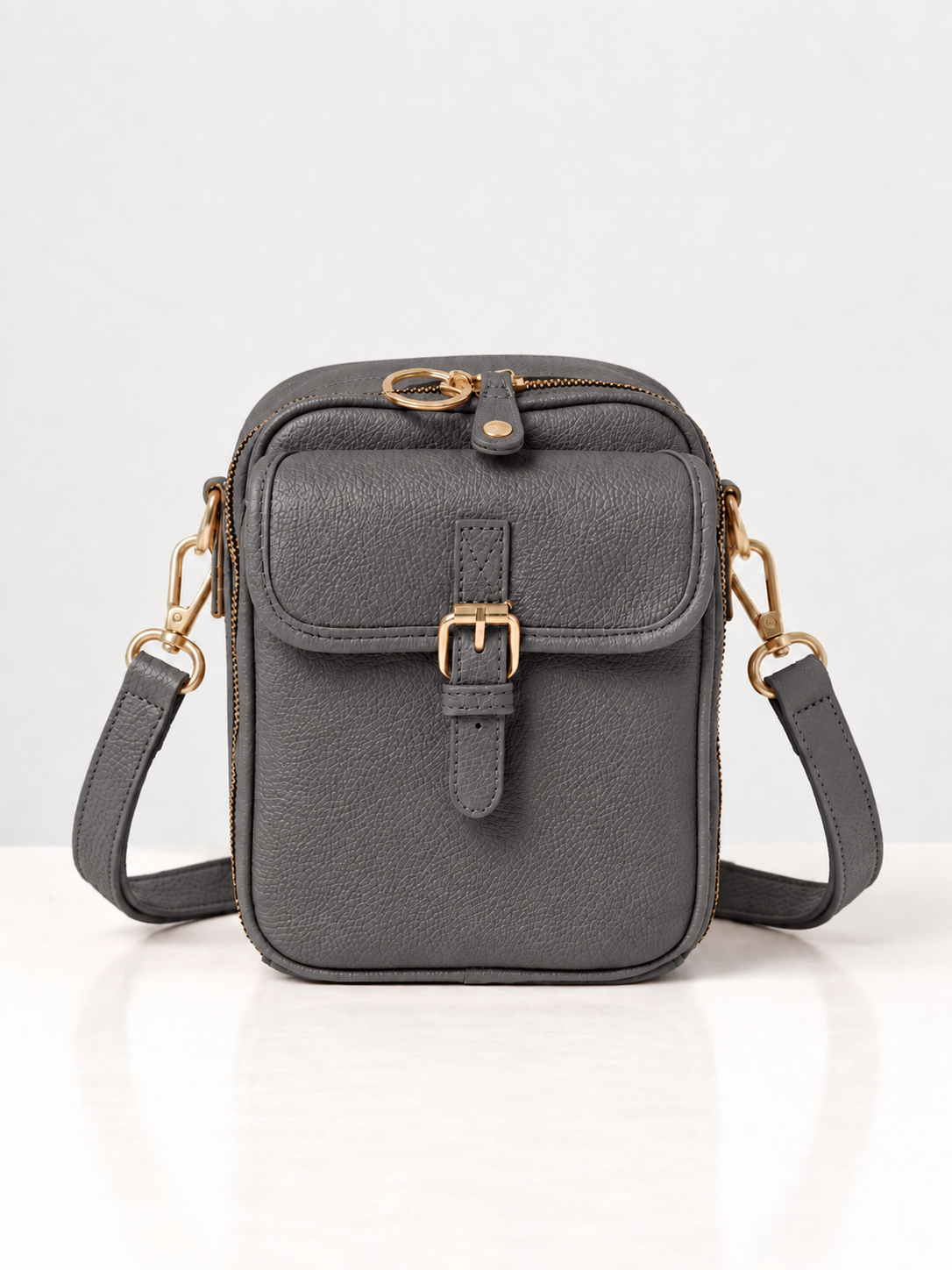 Sac bandoulière gris foncé en cuir synthétique, rabat avec boucle dorée et sangle réglable