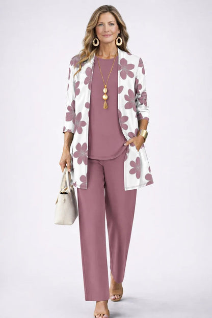 Ensemble trois pièces rose mauve: veste à fleurs, top uni et pantalon assorti.