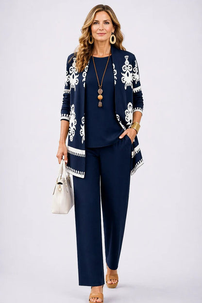 Ensemble trois pièces bleu nuit: veste à motifs, top bleu uni et pantalon assorti.