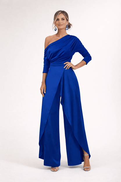 Combinaison bleue drapée une épaule, manches 3/4, taille ceinturée, jambes larges.