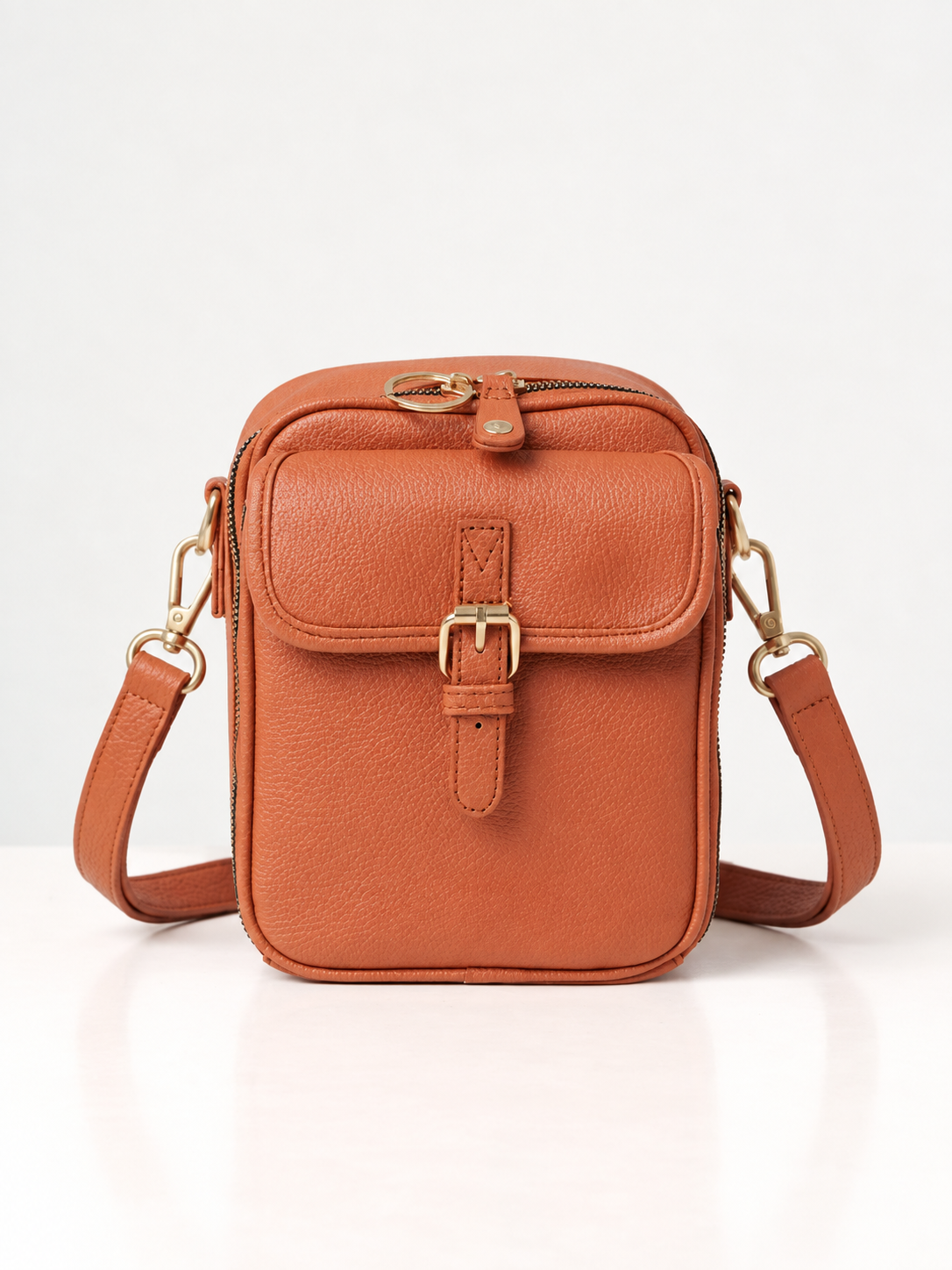 Sac bandoulière orange en cuir synthétique, rabat avec boucle dorée et sangle réglable