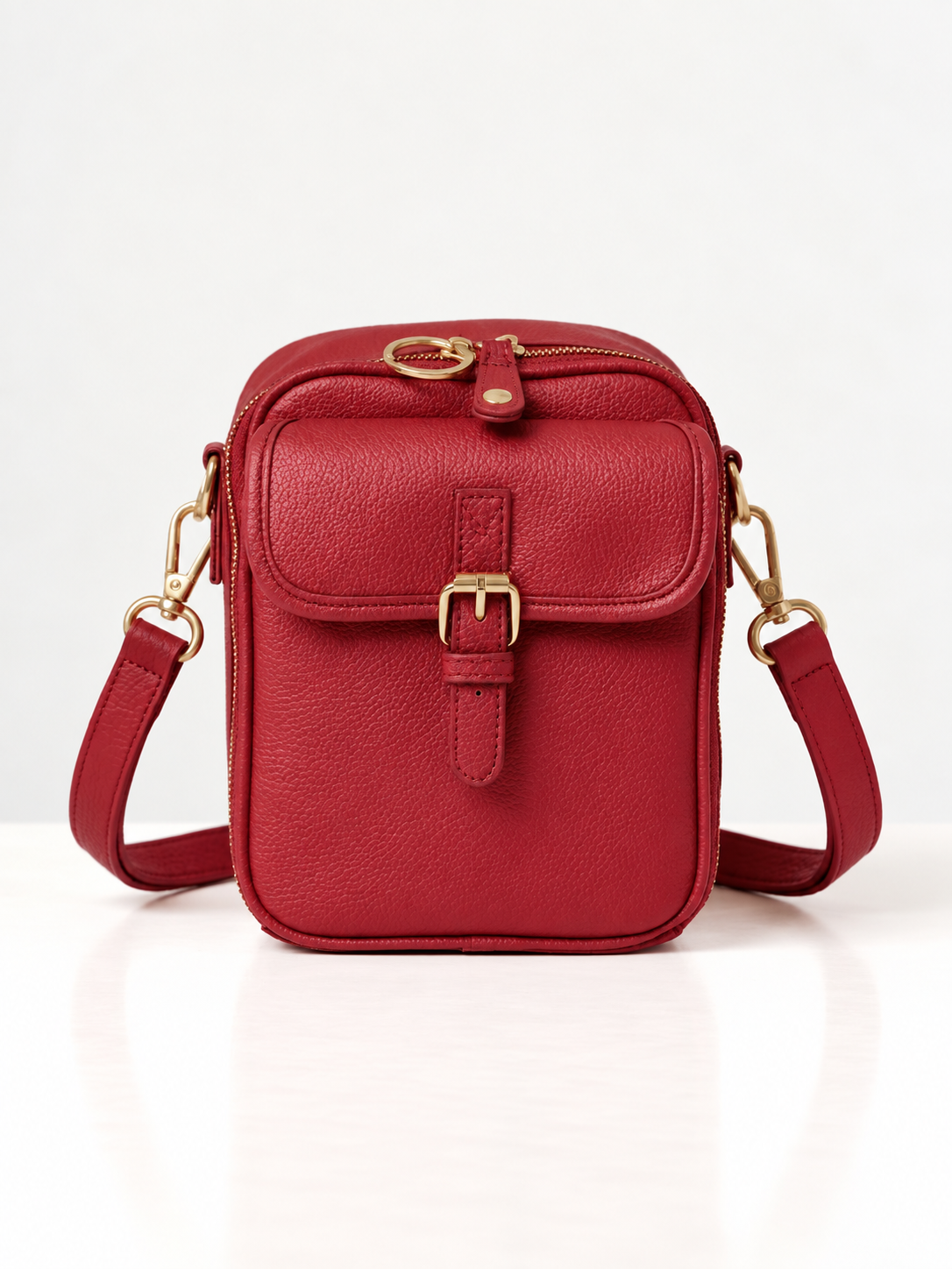 Sac bandoulière rouge en cuir synthétique, rabat avec boucle dorée et sangle réglable