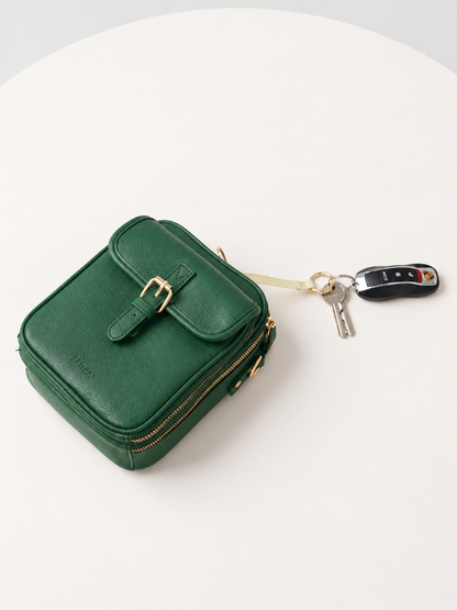 Petit sac bandoulière vert en cuir, fermeture zippée, porte-clés avec mousqueton.