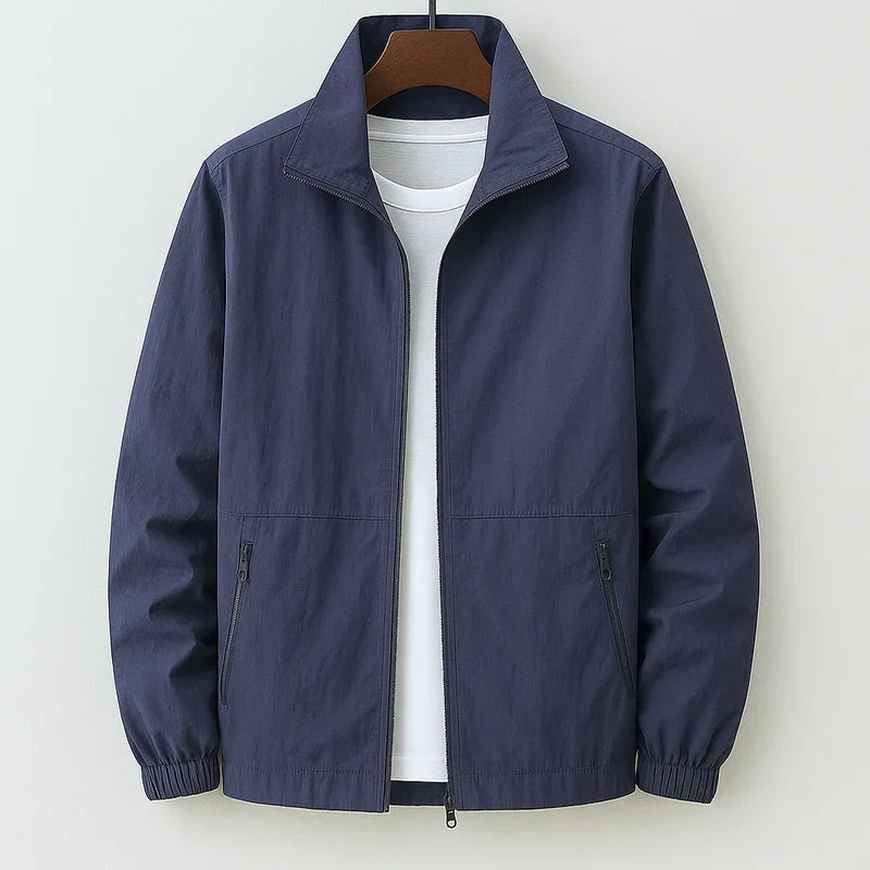 Blouson bomber léger bleu marine, zip central, col chemise, poignets élastiques, poches zippées.