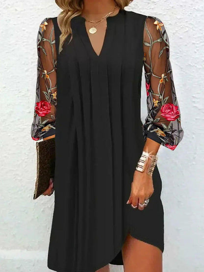 Robe noire élégante Camille, manches longues fleuries, coupe droite jusqu’au genou.