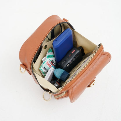 Sac bandoulière en cuir brun, zip ouvert, compartiments pour accessoires.