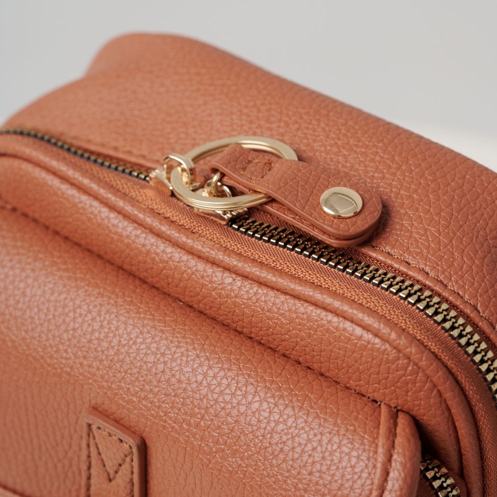 Sac bandoulière en cuir brun, fermeture zippée et attache métallique sur rabat.