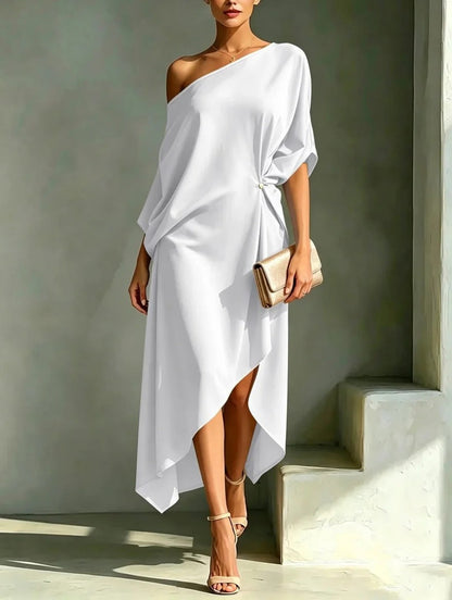 Robe asymétrique blanche, décolleté sur une épaule, manches chauve-souris, ourlet asymétrique