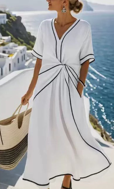 Robe décontractée blanche, encolure V et liserés noirs, ceinture nouée, manches courtes