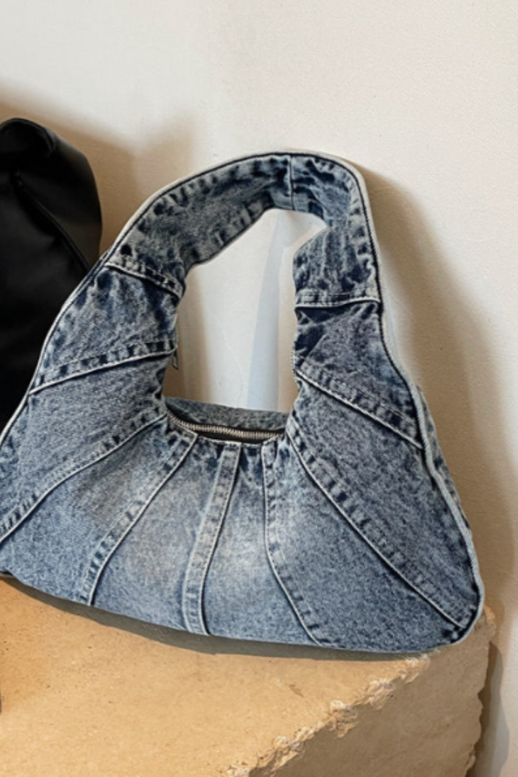 Sac hobo en jean bleu délavé, ouverture avec doublure claire visible.