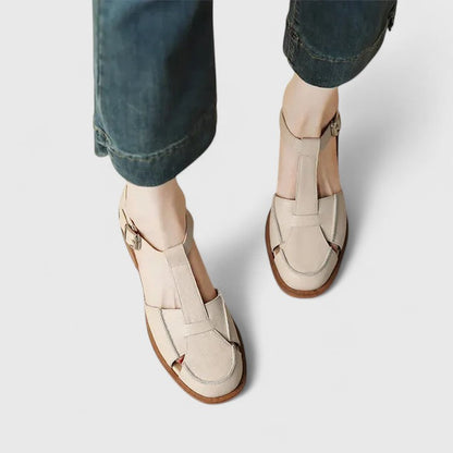 Sandales bébé beige à découpe latérale, brides croisées et boucle, semelle marron.