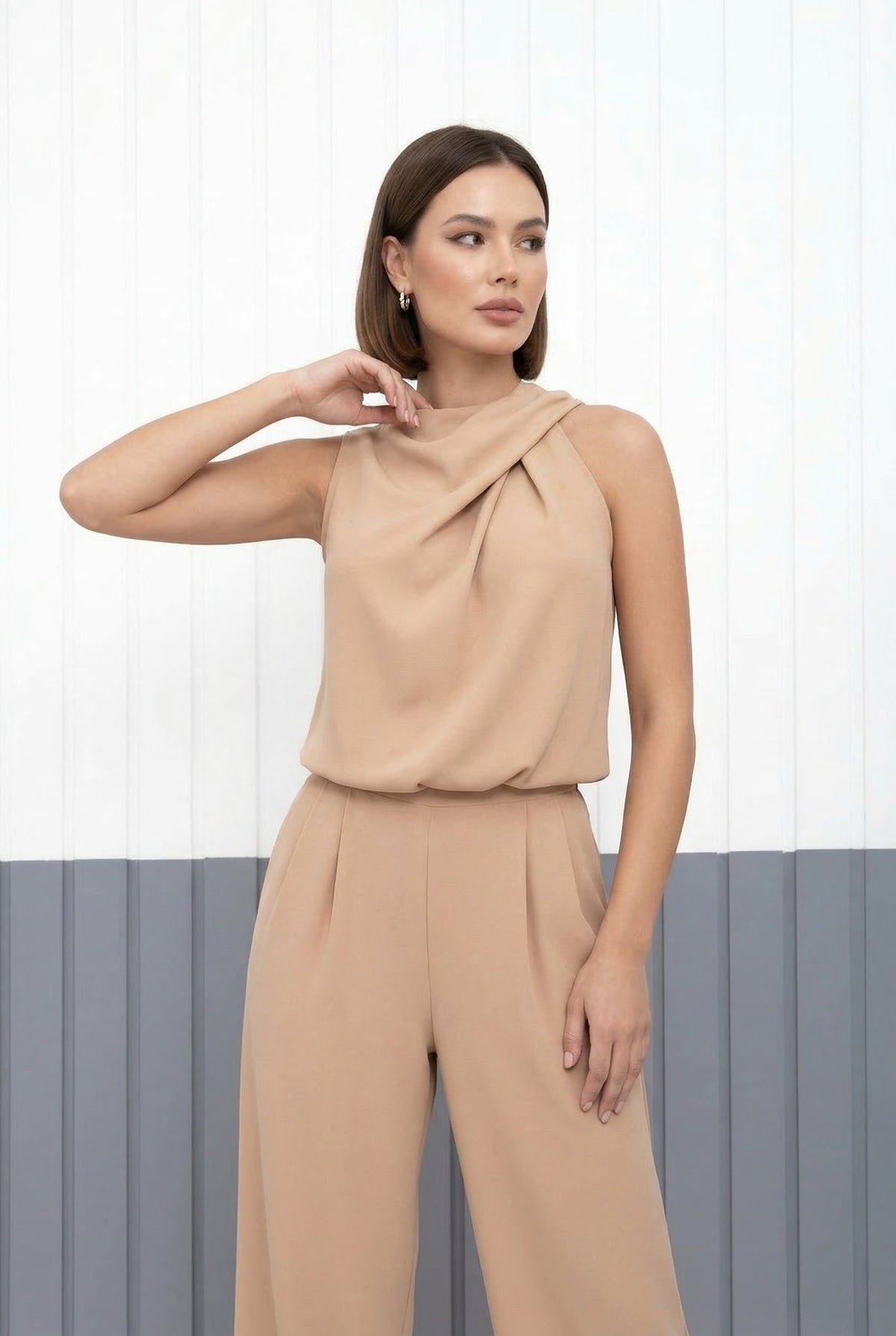 Combinaison sans manches beige, drapé au buste et pantalon taille haute.