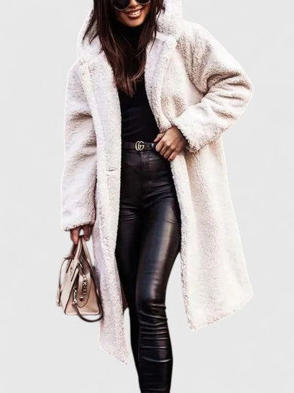 Veste longue en tissu bouclé blanc cassé, col châle, poches et boutonnage discret.