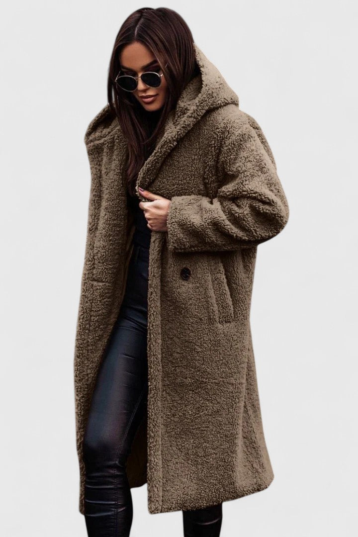 Veste longue en tissu bouclé beige chiné, col châle, poches et boutonnage discret.