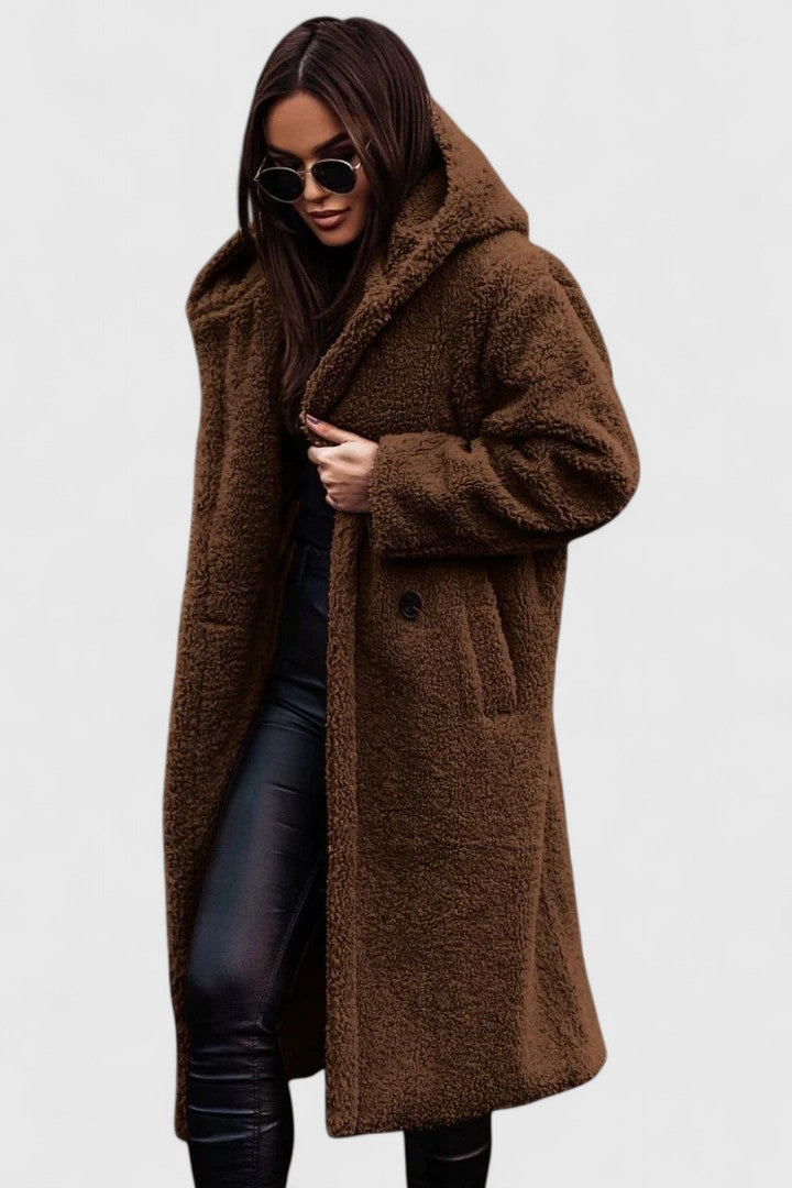Veste longue en tissu bouclé marron, col châle, poches et boutonnage discret.