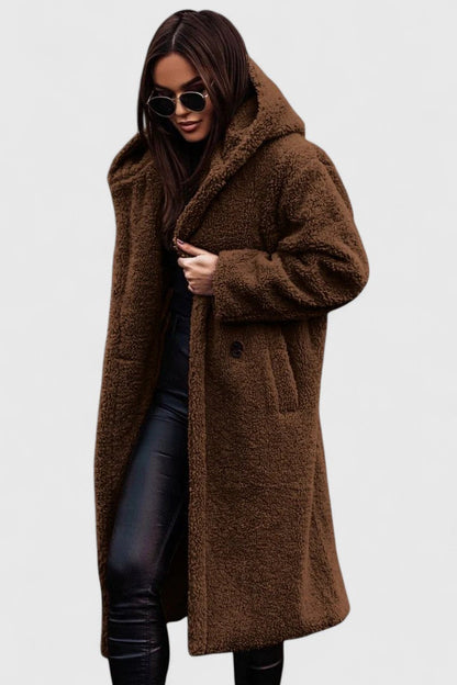 Veste longue en tissu bouclé marron, col châle, poches et boutonnage discret.