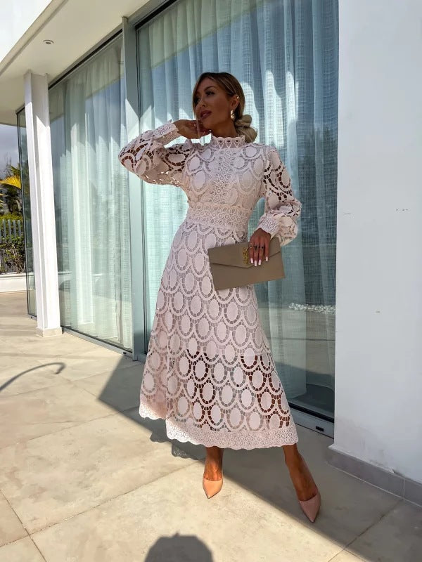 Robe en dentelle romantique blanche, manches longues, col montant, longueur midi.