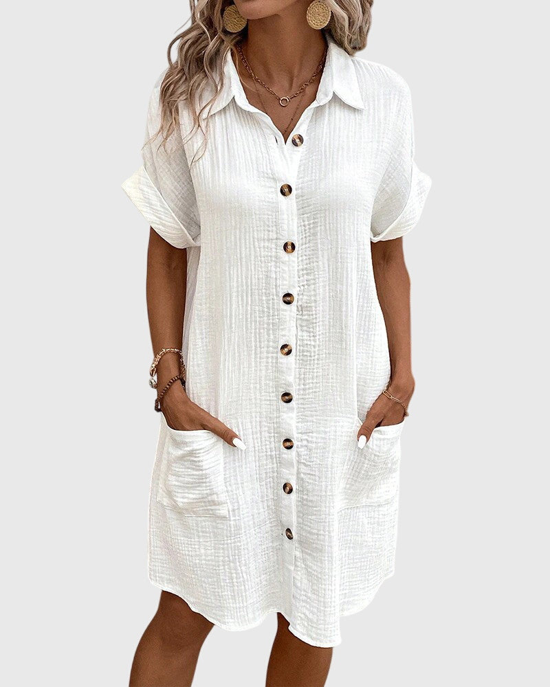 Robe blanche boutonnée, col chemise, manches courtes et poches sur le côté