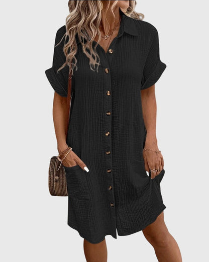 Robe noire boutonnée, col chemise, manches courtes et poche latérale