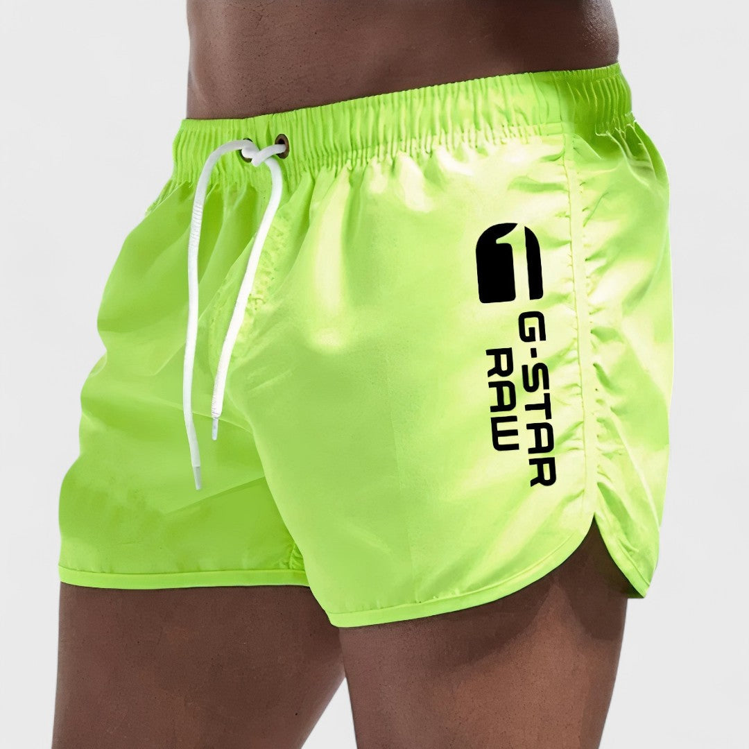 Short de bain homme vert fluo, cordon blanc, logo imprimé sur la jambe.