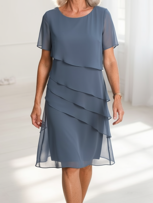 Robe fluide bleu clair à volants superposés, manches courtes, jupe mi-longue.