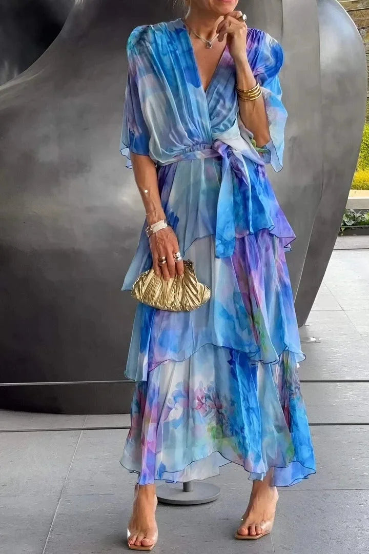Robe en chiffon bleu à volants superposés et lien à la taille, manches évasées.
