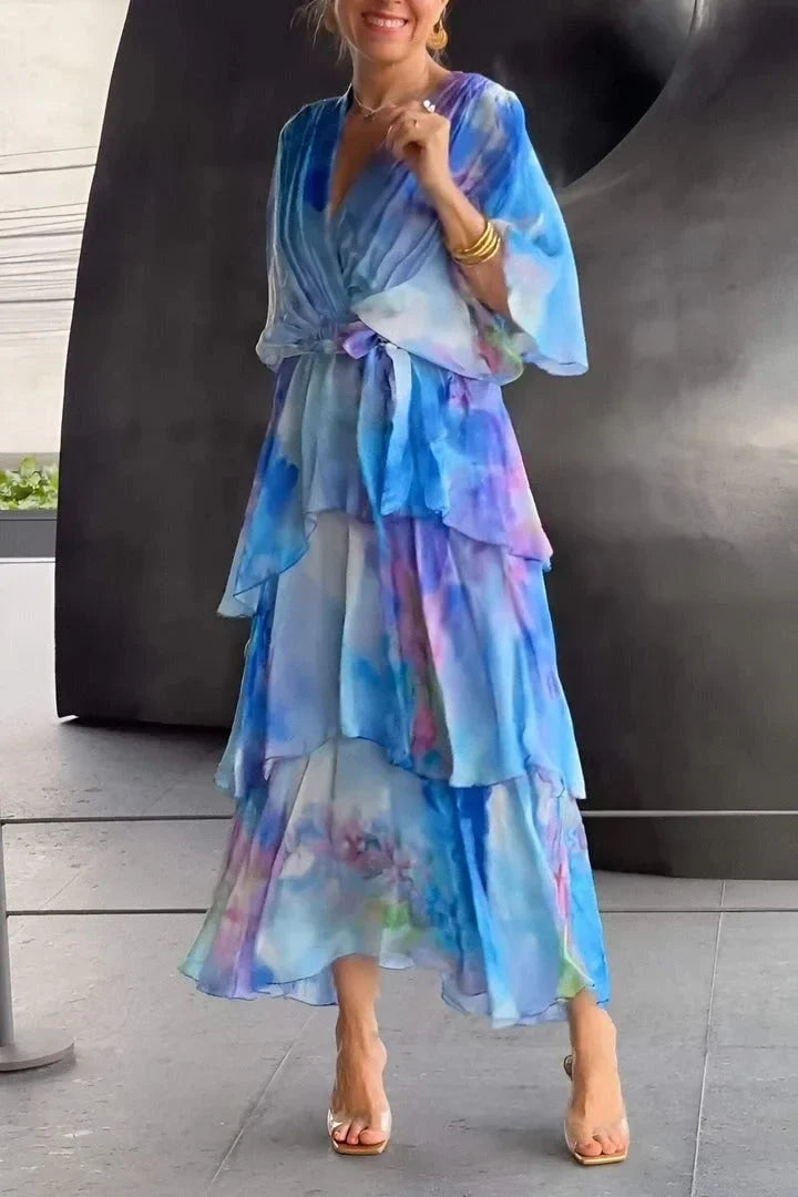 Robe en chiffon bleu dégradé, volants superposés et ceinture nouée, manches bouffantes.