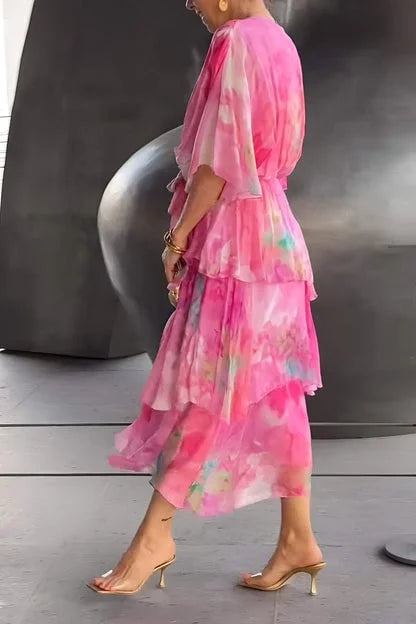 Robe en chiffon rose dégradé, volants étagés au dos, manches évasées.