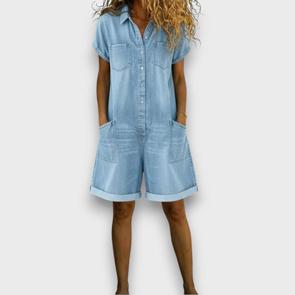 Salopette courte en denim bleu clair, surpiqûres visibles et poches plaquées