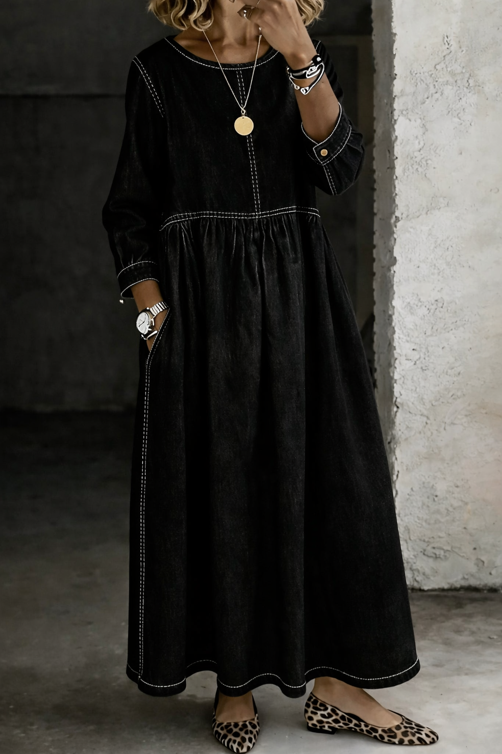 Robe noire ample, col rond, manches longues, surpiqûres et taille froncée