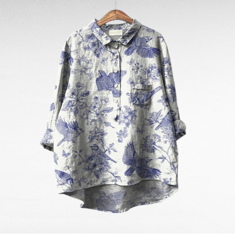 Blouse à col chemise blanche, imprimé floral bleu, boutonnée, manches trois-quarts.
