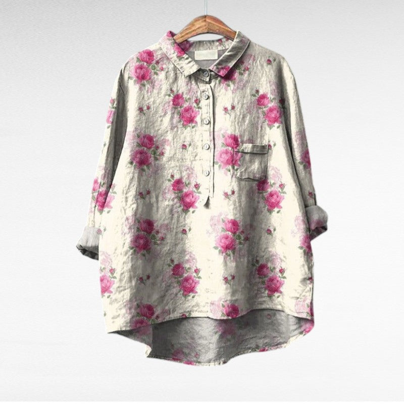 Blouse à col chemise gris clair, fleurs roses, poche poitrine, boutonnée, manches trois-quarts.