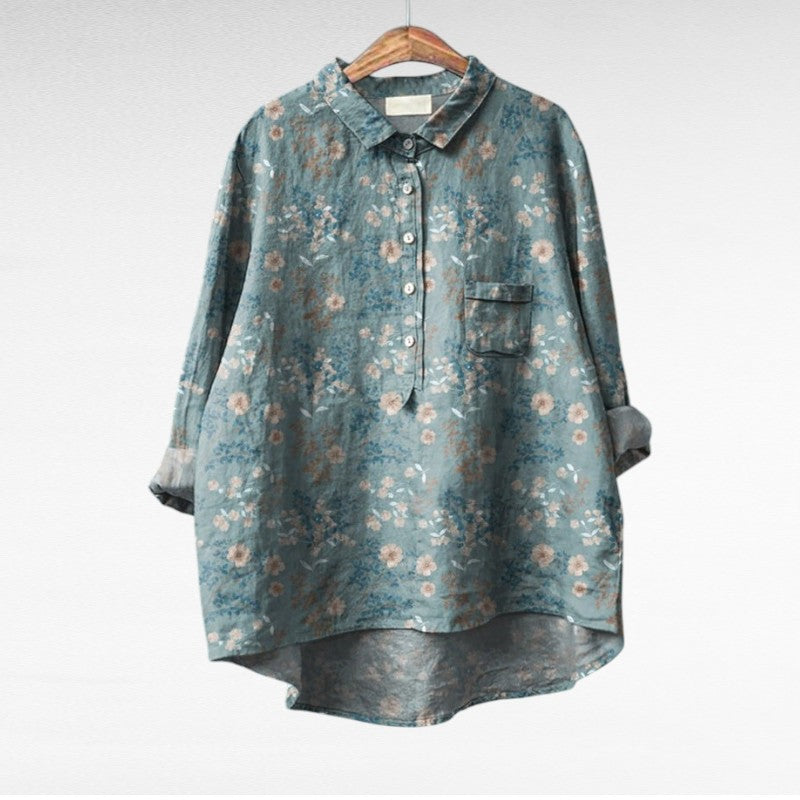 Blouse à col chemise bleu-vert, imprimé fleuri beige, poche poitrine, boutonnée.