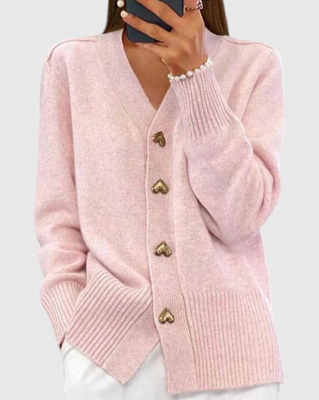 Cardigan rose clair à col V, boutons dorés, manches longues et poignets côtelés.