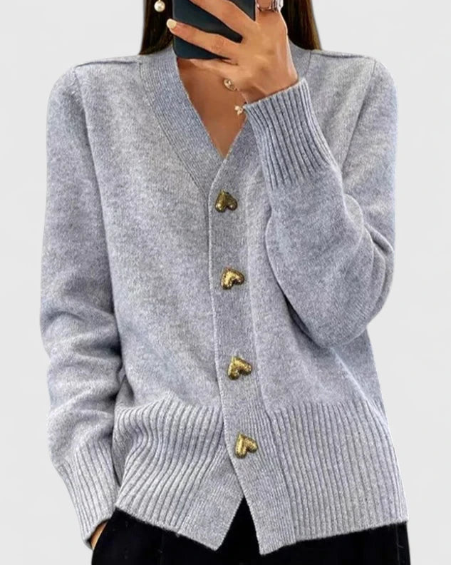 Cardigan gris à col V, boutons dorés, manches longues et bas côtelés.