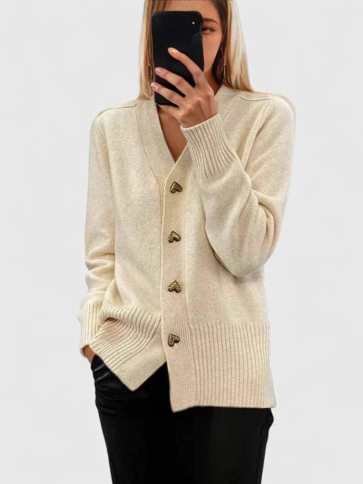 Cardigan crème à col V, boutons dorés, manches longues et bordure côtelée.