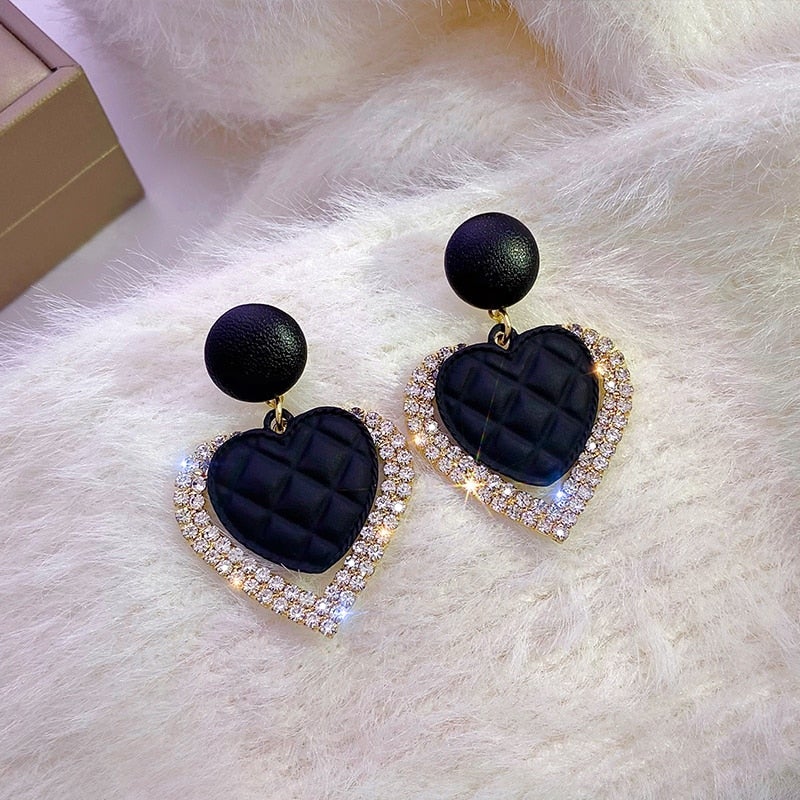 Boucles d’oreilles cœur noir mat, monture dorée et bordure de strass brillants