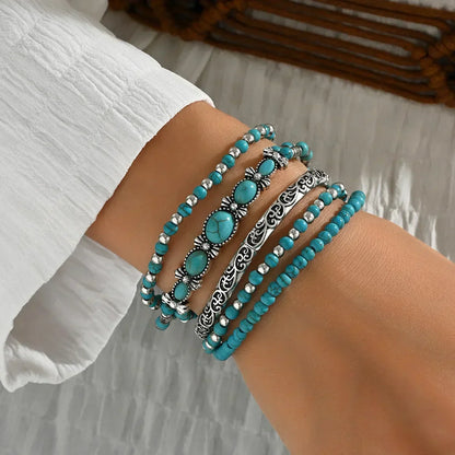 Lot de bracelets perles turquoise et éléments argentés, portés au poignet
