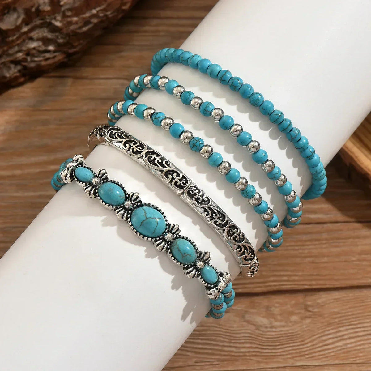 Bracelets perles turquoise, coques argentées et pendentifs, sur poignet