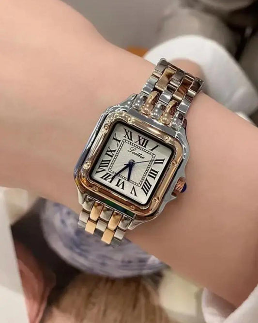 Montre femme au poignet, cadran carré romain, bracelet acier bicolore, aiguilles bleues