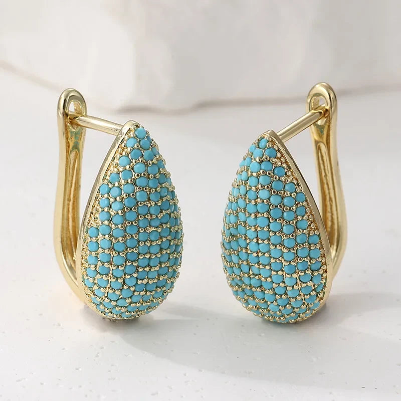 Paire de boucles d’oreilles larme turquoise pavées, monture dorée à charnière