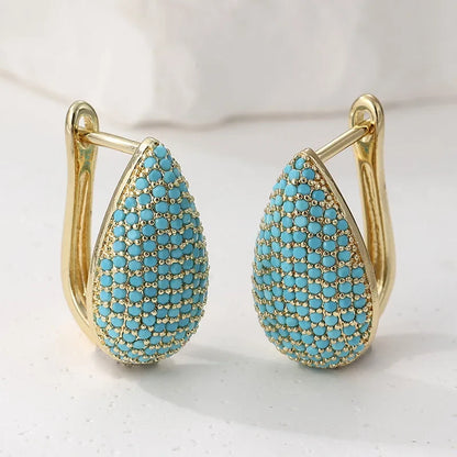 Paire de boucles d’oreilles larme turquoise pavées, monture dorée à charnière